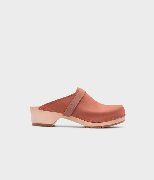 classic low heeled clog mule in blush pink nubuck leather stapled on a light wooden base with a leather strap