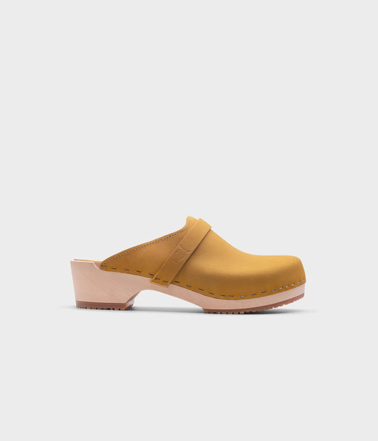 classic low heeled clog mule in yellow nubuck leather stapled on a light wooden base with a leather strap