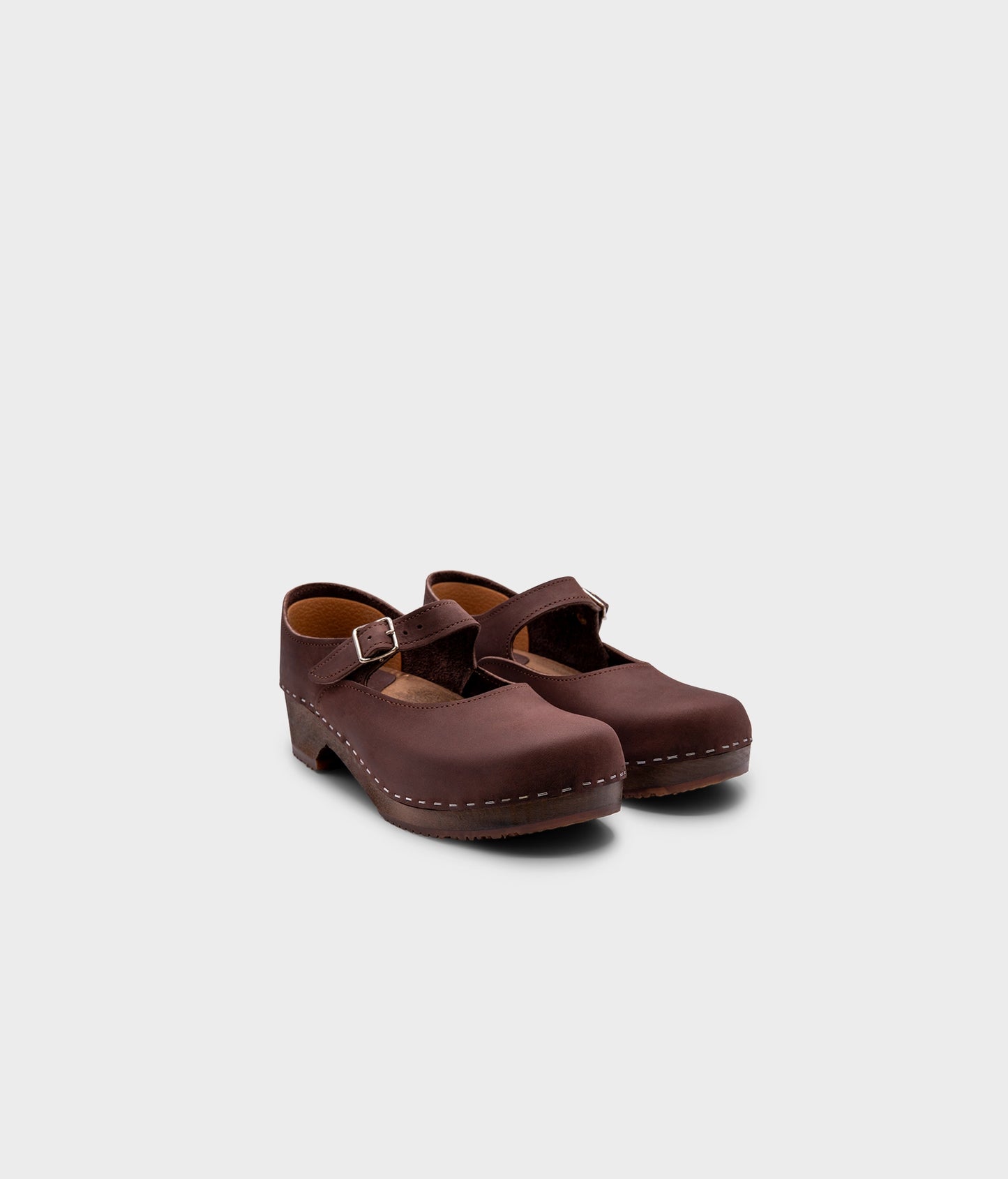 Mary Jane wooden clogs in dark brown nubuck leather stapled on a dark wooden base