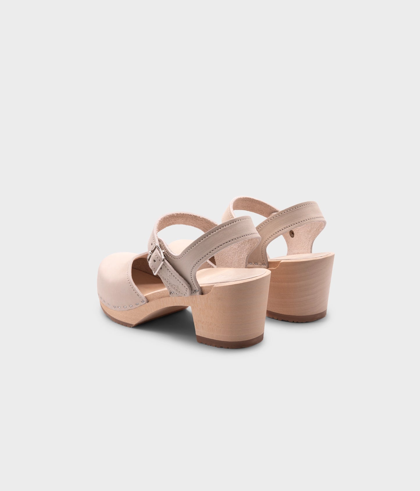 high heeled closed-toe clog sandal in sand white nubuck leather stapled on a light wooden base