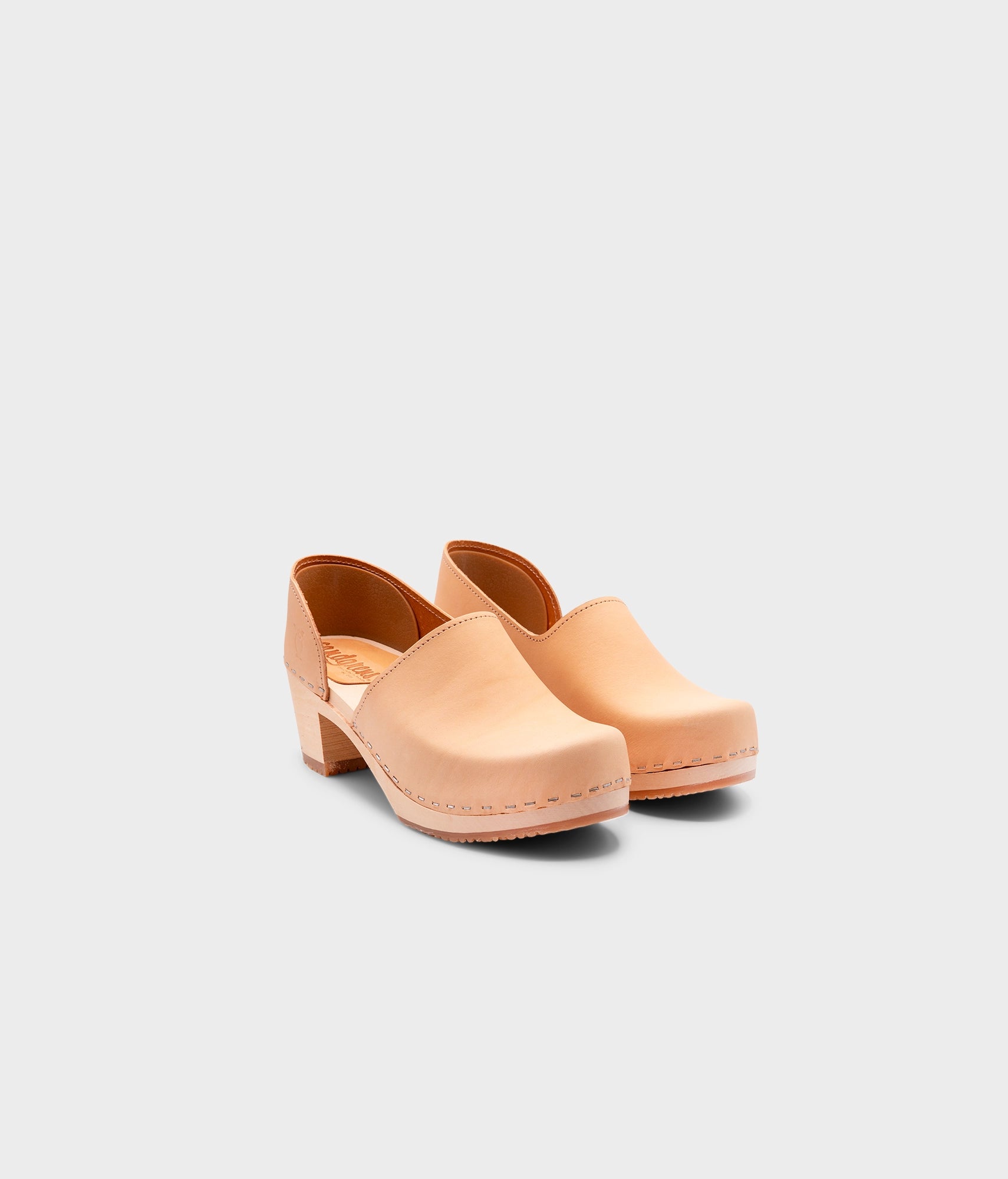 high heeled closed-back clogs in beige ecru vegetable tanned leather stapled on a light wooden base