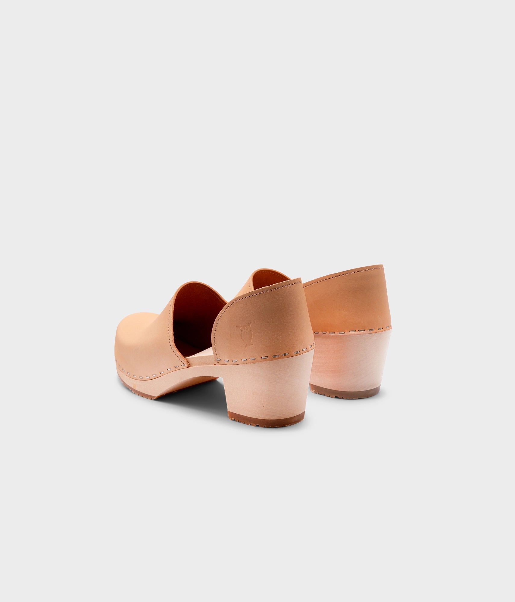 high heeled closed-back clogs in beige ecru vegetable tanned leather stapled on a light wooden base