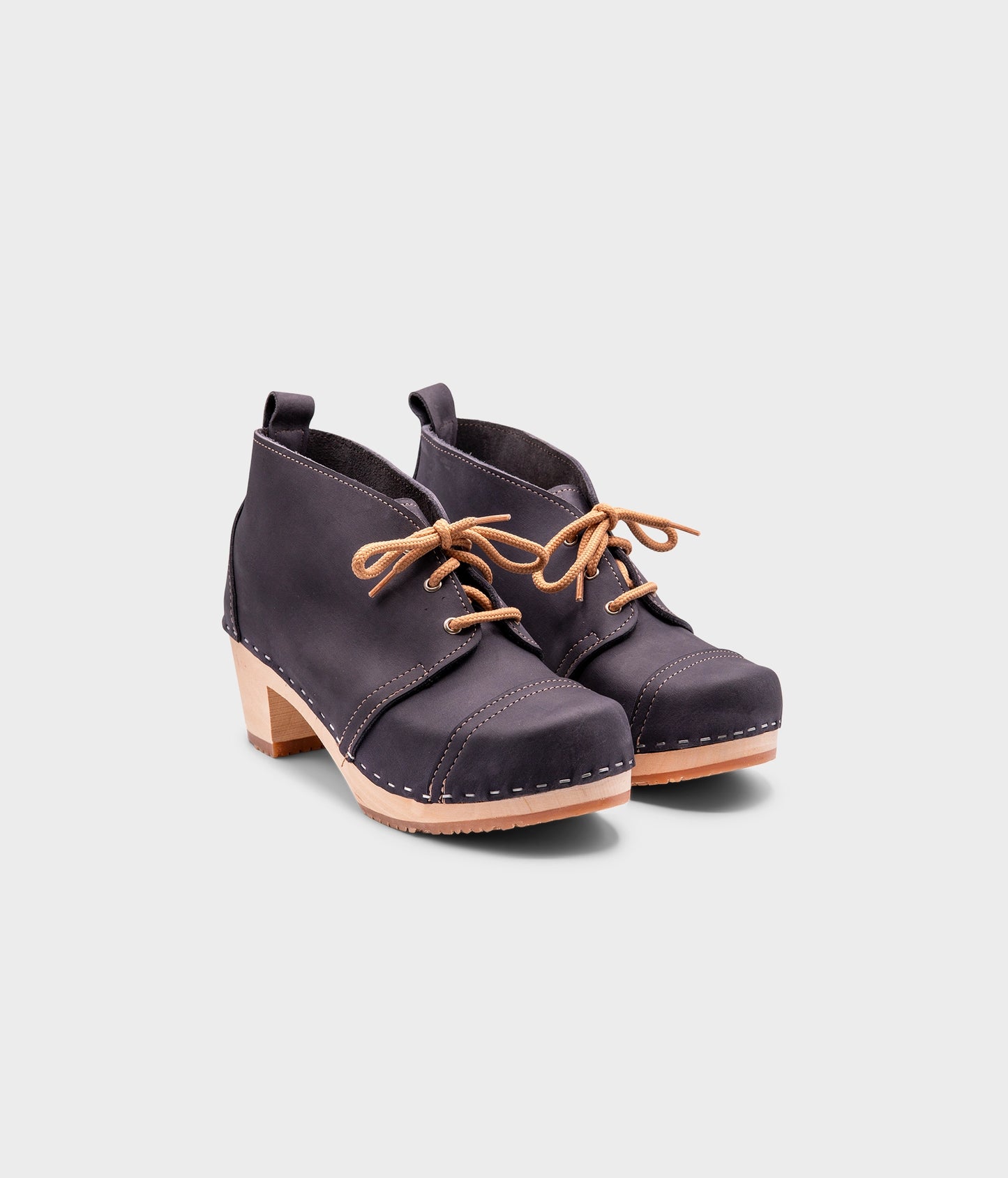 high heeled chukka clog boots in navy blue nubuck leather stapled on a light wooden base with beige laces