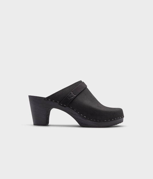 classic high rise heel clog mule in black nubuck leather stapled on a black wooden base