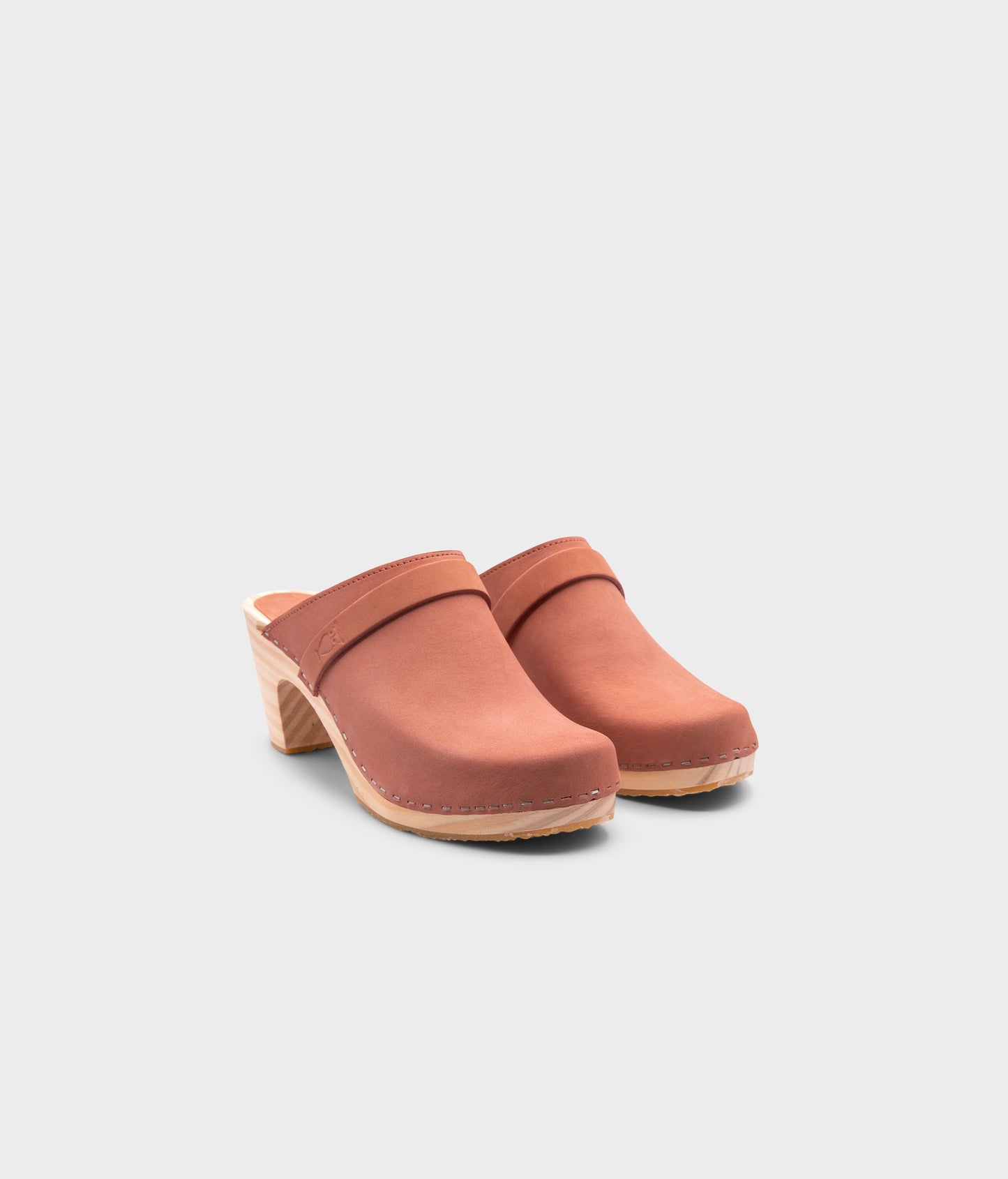 classic high rise heel clog mule in blush pink nubuck leather stapled on a light wooden base