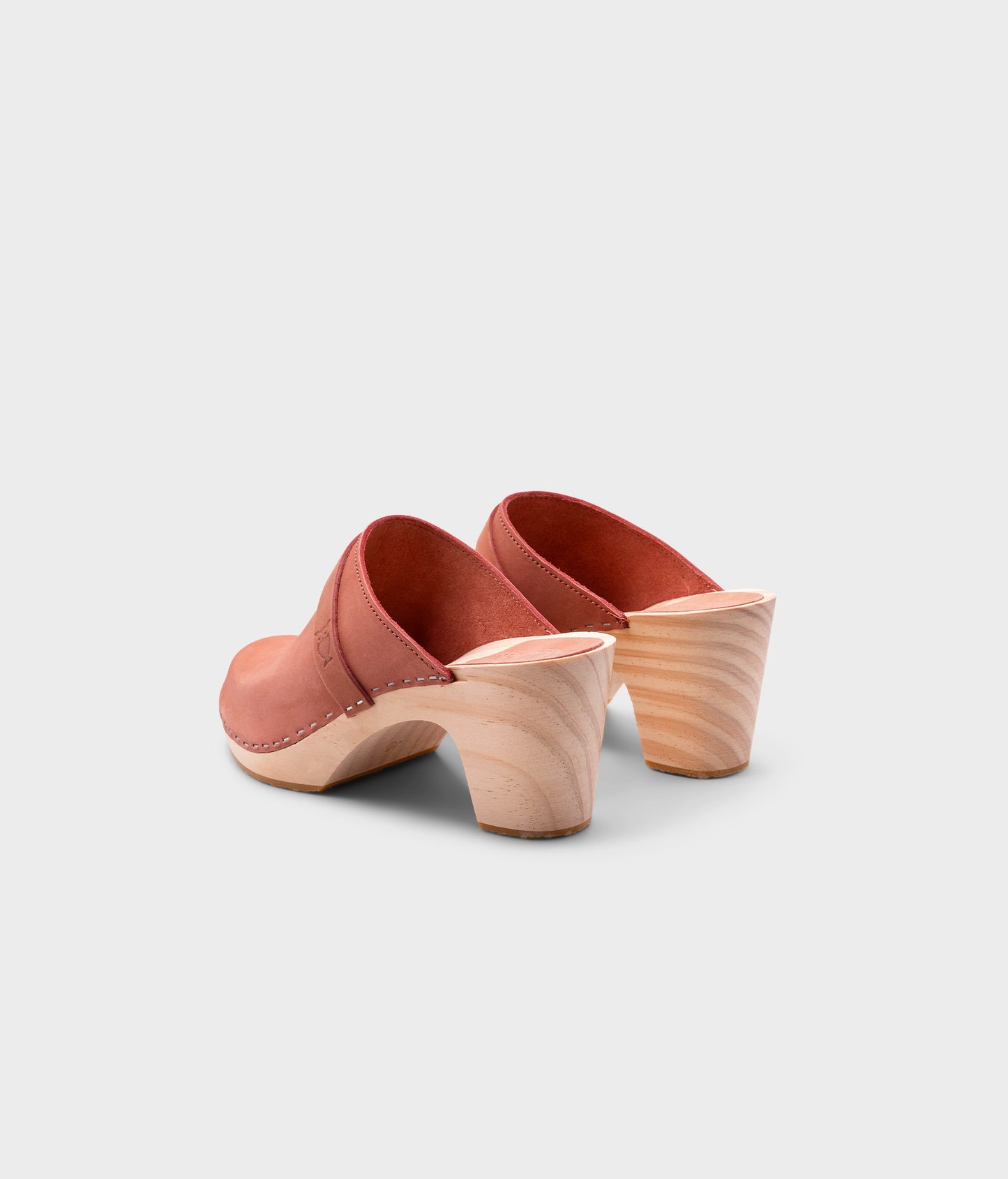 classic high rise heel clog mule in blush pink nubuck leather stapled on a light wooden base