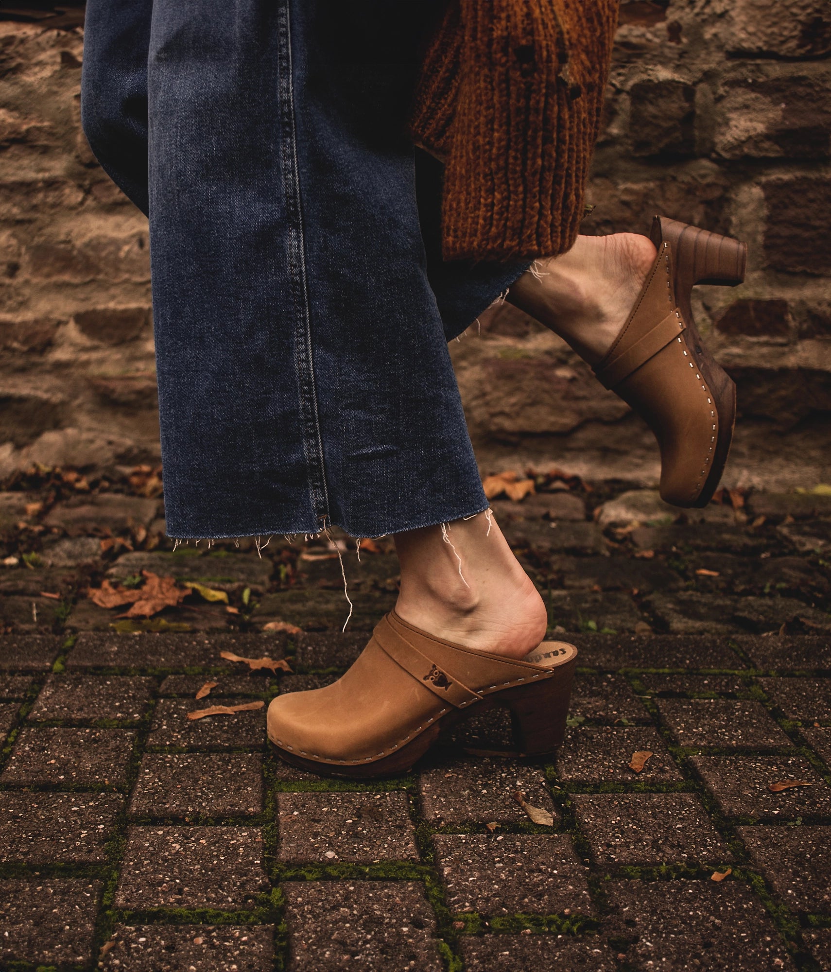 classic high rise heel clog mule in light brown nubuck leather stapled on a dark wooden base