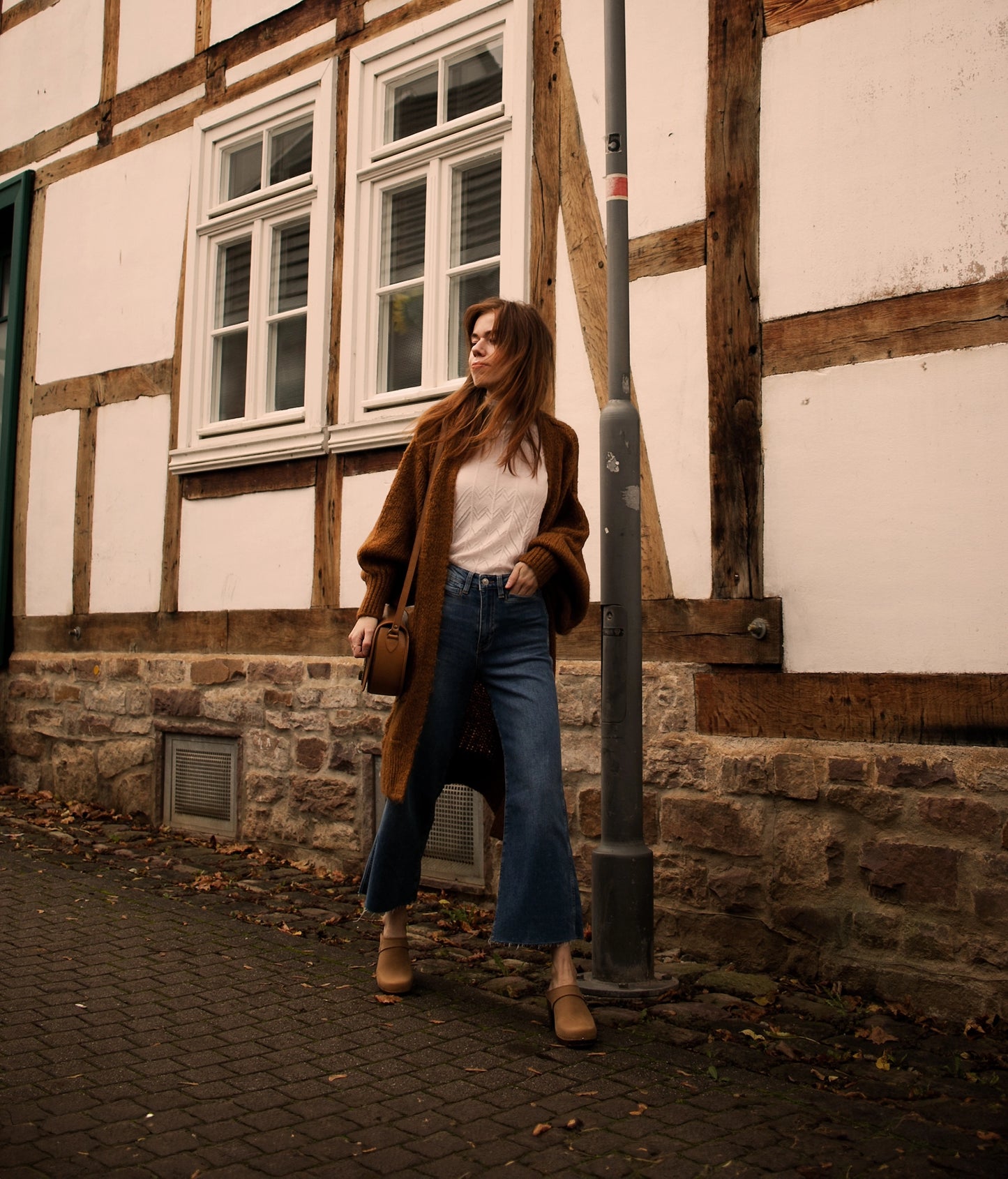 classic high rise heel clog mule in light brown nubuck leather stapled on a dark wooden base