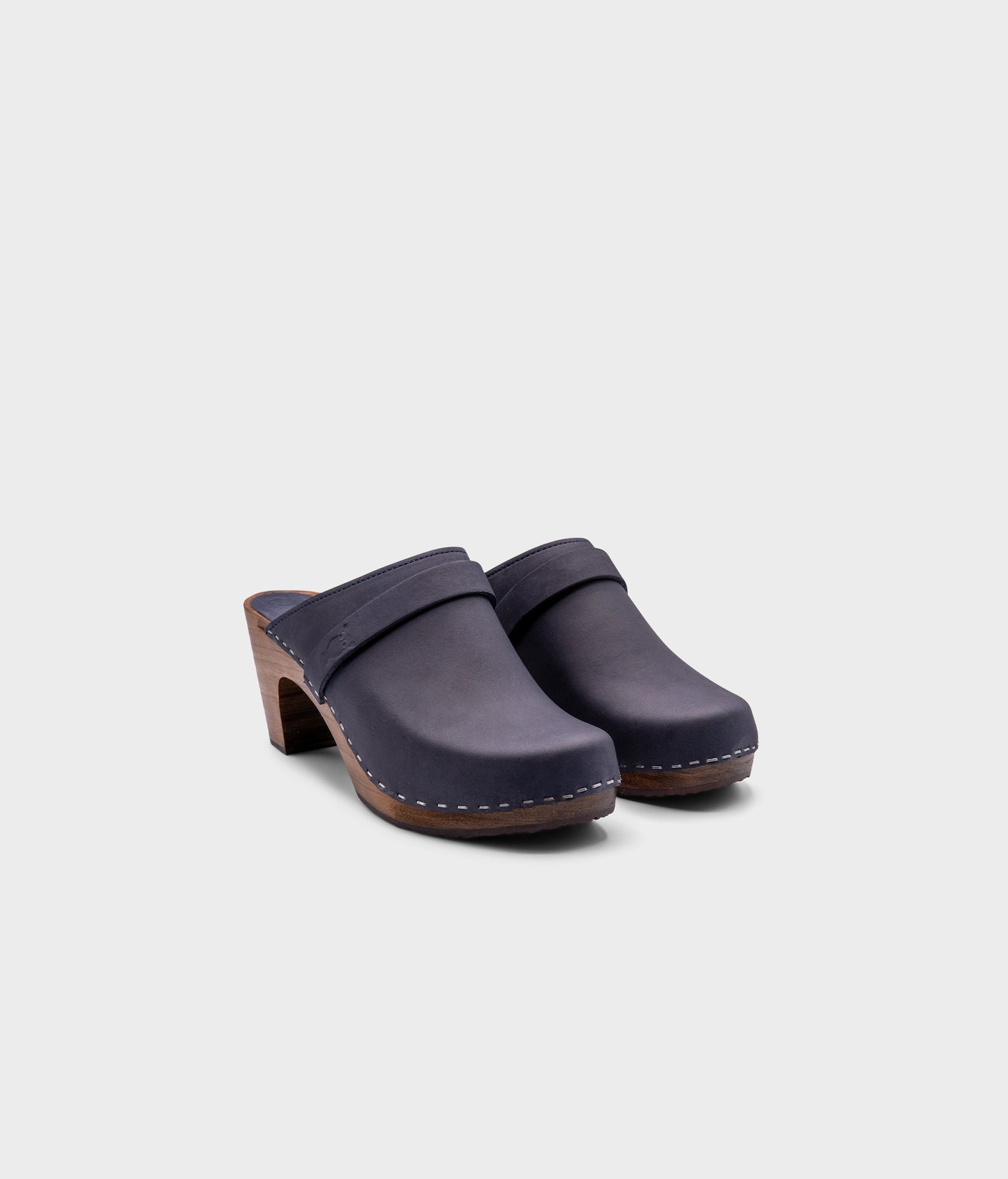 classic high rise heel clog mule in navy blue nubuck leather stapled on a dark wooden base