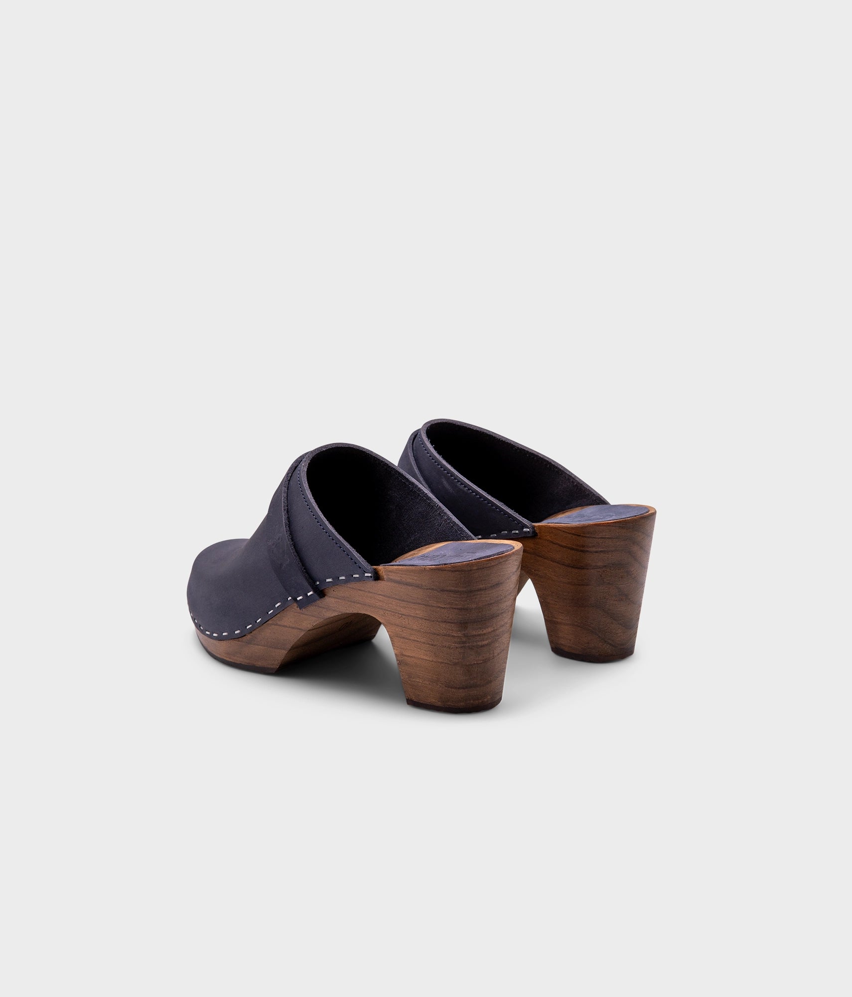 classic high rise heel clog mule in navy blue nubuck leather stapled on a dark wooden base