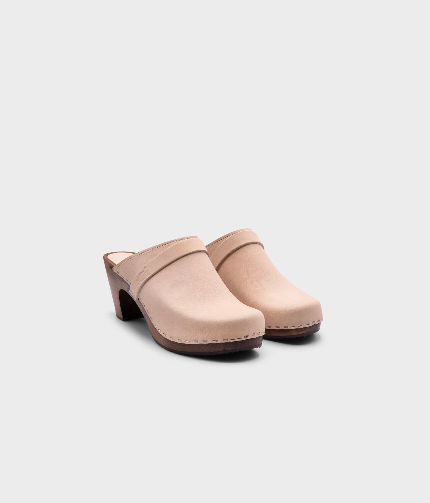 classic high rise heel clog mule in white sand nubuck leather stapled on a dark wooden base