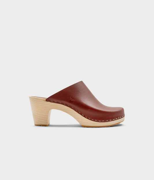 high rise minimalistic clog mule in cognac red vegetable tanned leather stapled on a light wooden base