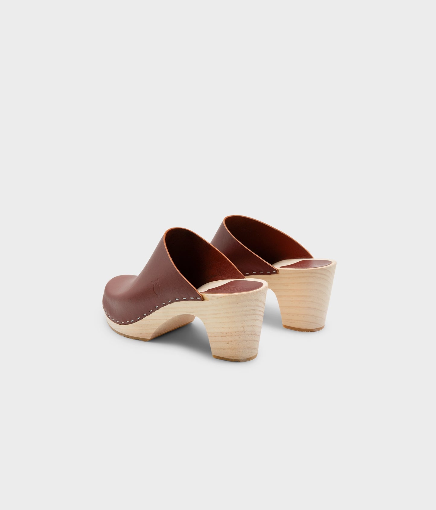 high rise minimalistic clog mule in cognac red vegetable tanned leather stapled on a light wooden base