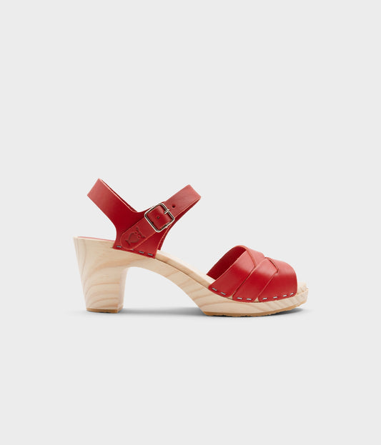 High rise heel clog sandals in red vegetable tanned leather stapled on a light wooden base with an open toe
