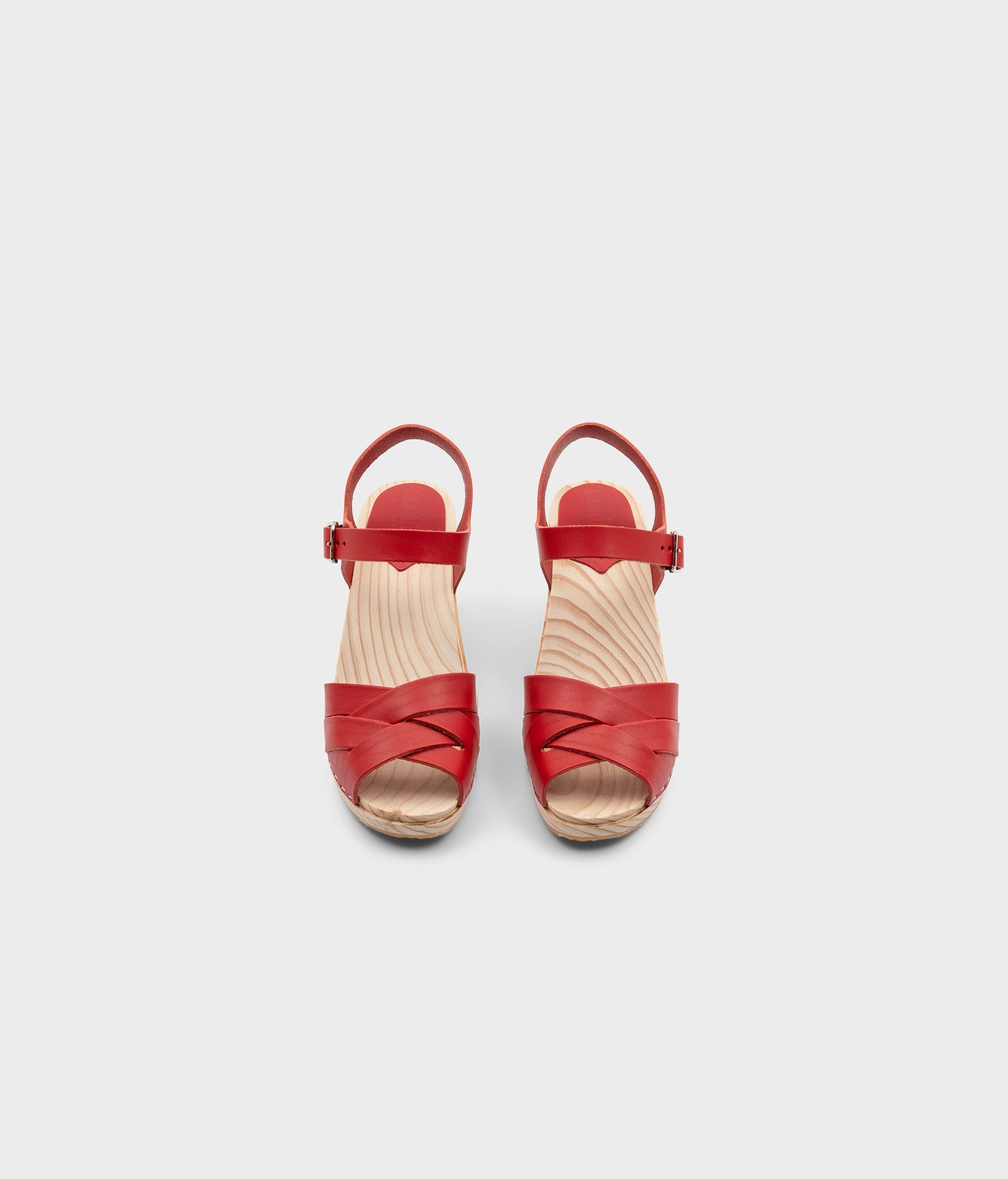 High rise heel clog sandals in red vegetable tanned leather stapled on a light wooden base with an open toe