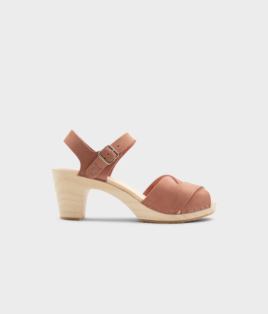 high rise heel crossed clog sandals in blush pink nubuck leather stapled on a light wooden base
