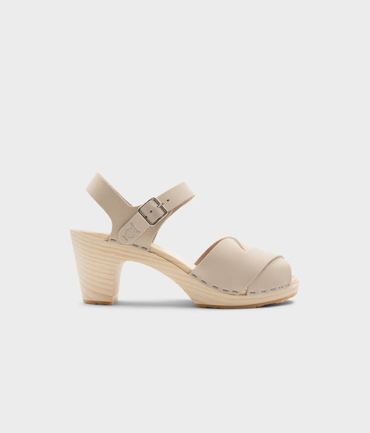 high rise heel crossed clog sandals in white sand nubuck leather stapled on a light wooden base