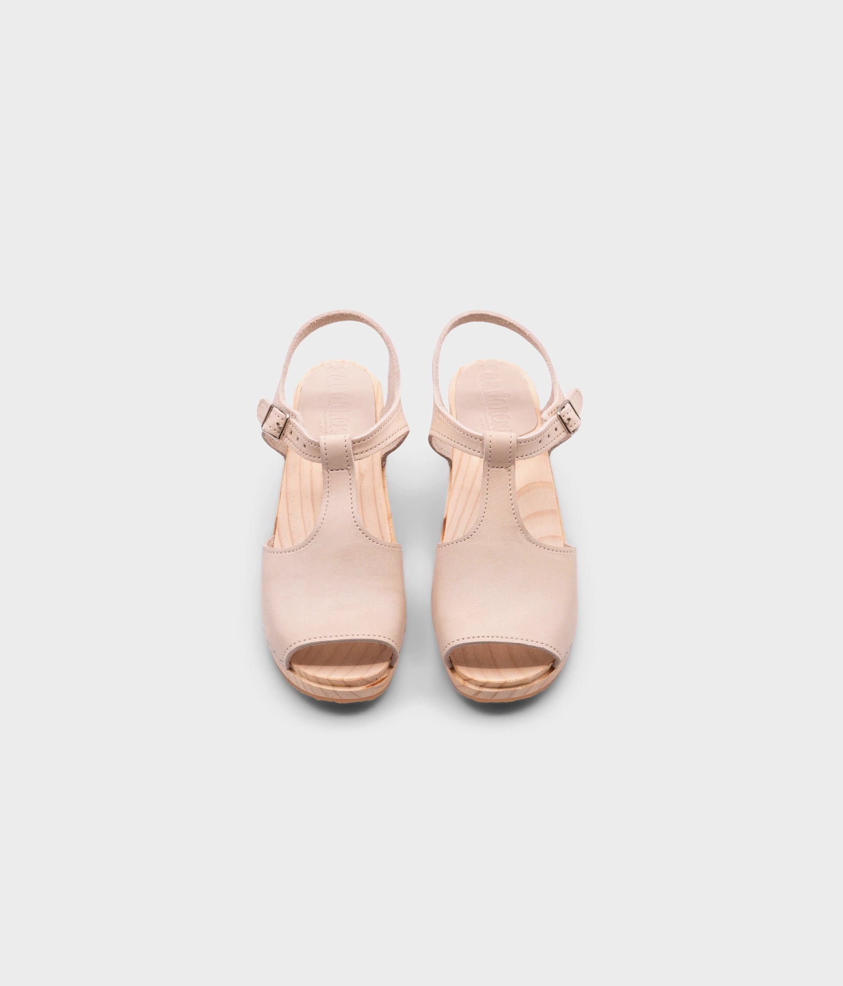 high rise heeled open toe clog sandal in sand white nubuck leather stapled on a light wooden base