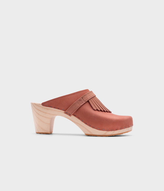 high rise clog mule in blush pink nubuck leather stapled on a light wooden base with a leather strap with fringes