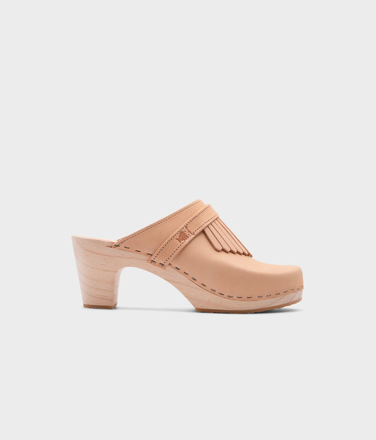 high rise clog mule in ecru beige vegetable tanned leather stapled on a light wooden base with a leather strap with fringes