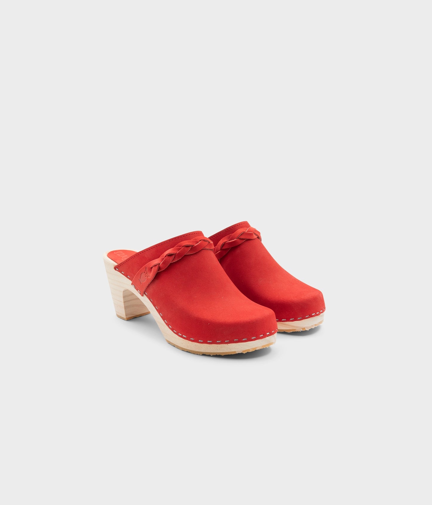 high rise heel braided clog mule in red leather stapled on a light wooden base