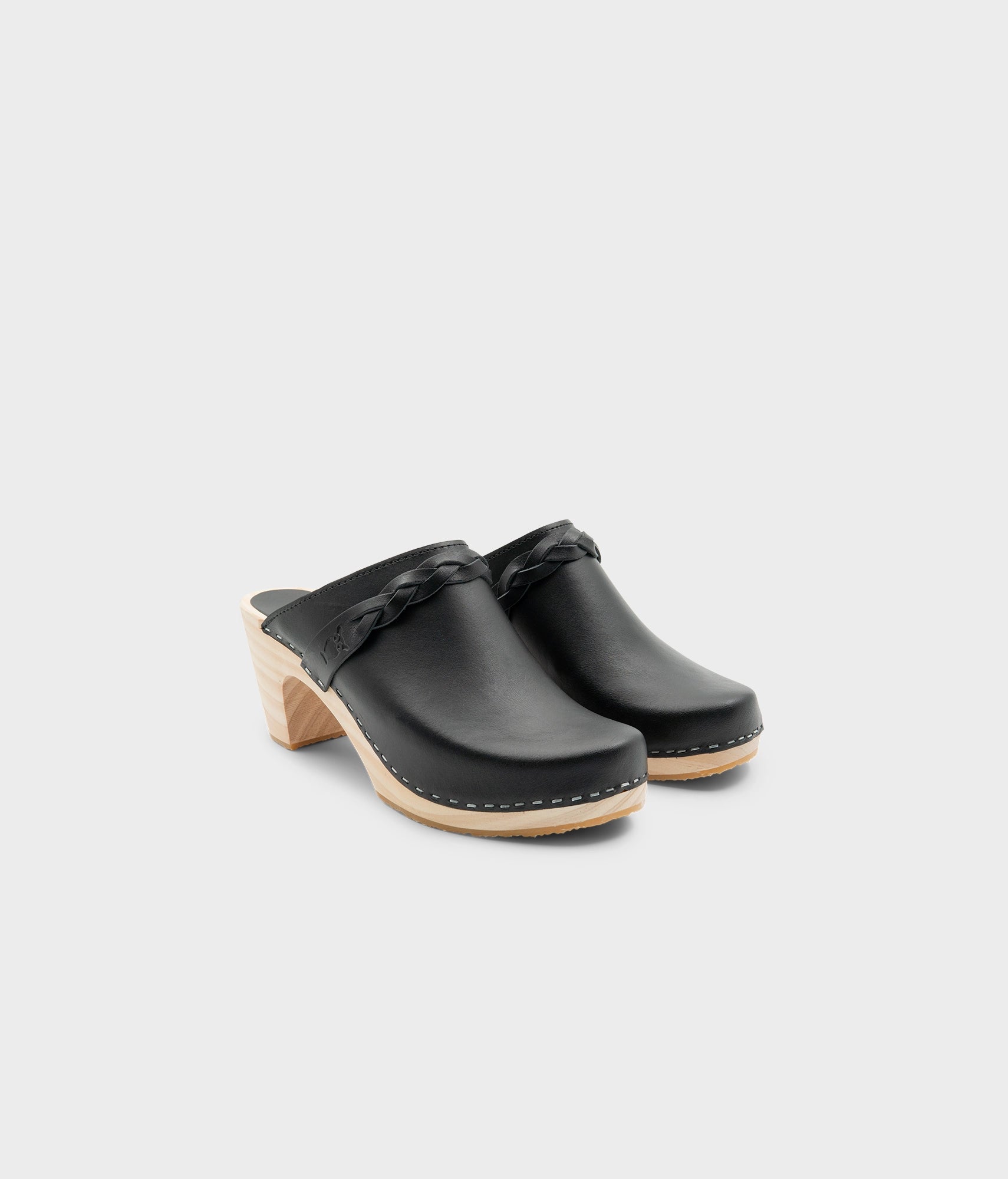 high rise heel braided clog mule in black vegetable tanned leather stapled on a light wooden base