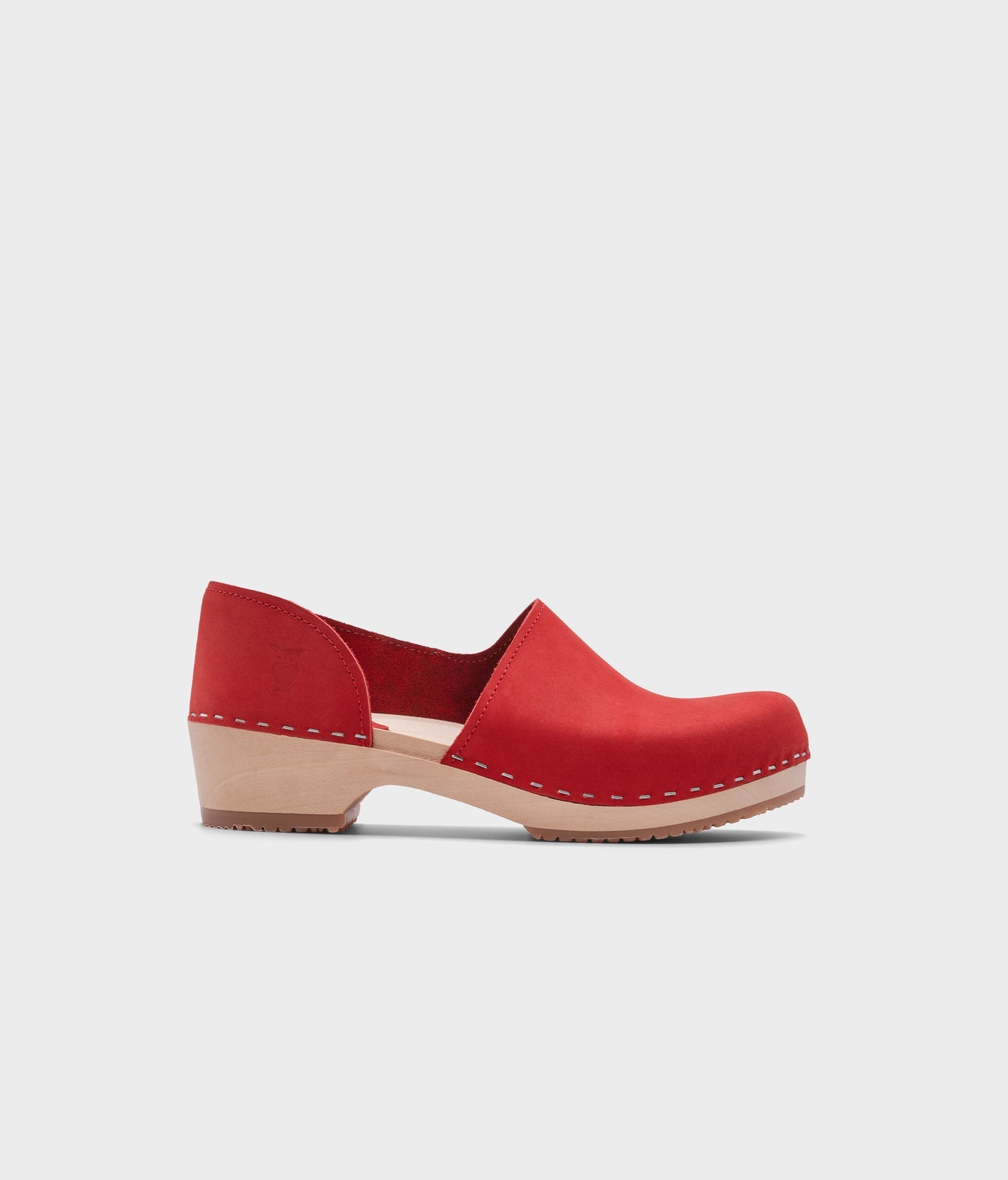 low heeled closed-back clogs in red nubuck leather stapled on a light wooden base