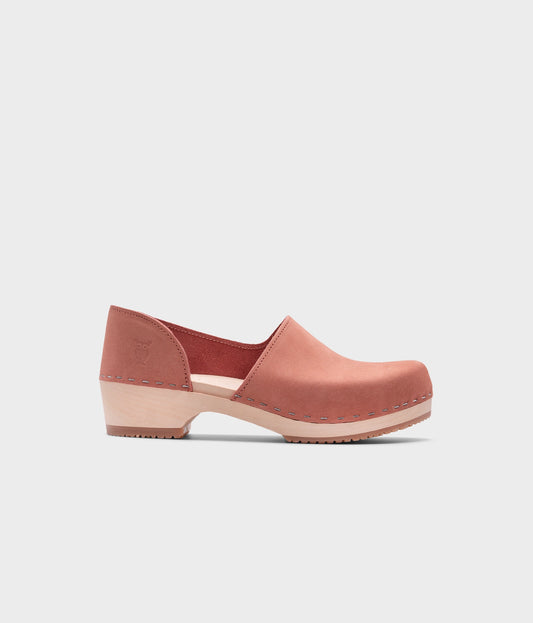 low heeled closed-back clogs in blush pink nubuck leather stapled on a light wooden base