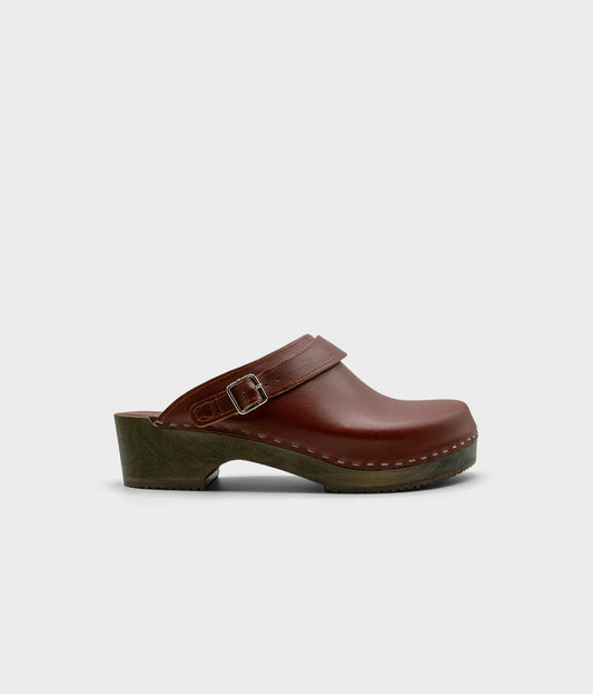 men's low heeled clog mules in cognac red vegetable tanned leather stapled on a dark wooden base with a sling back
