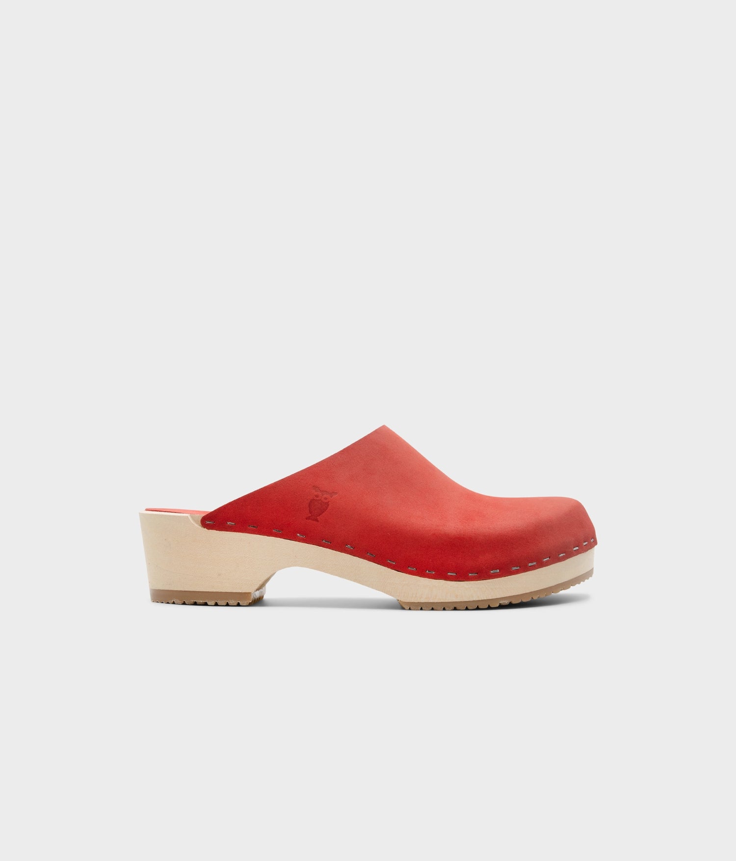 low heeled minimalistic clog mules in red nubuck leather stapled on a light wooden base