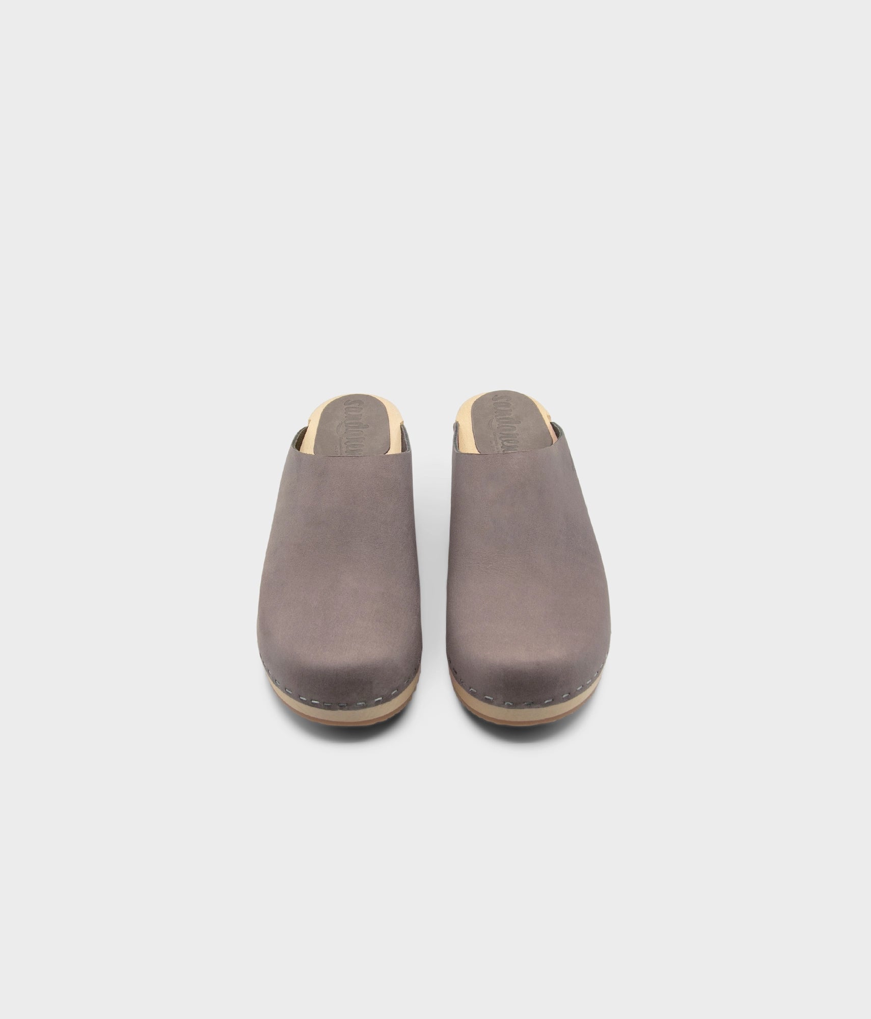 low heeled minimalistic clog mules in stone grey nubuck leather stapled on a light wooden base