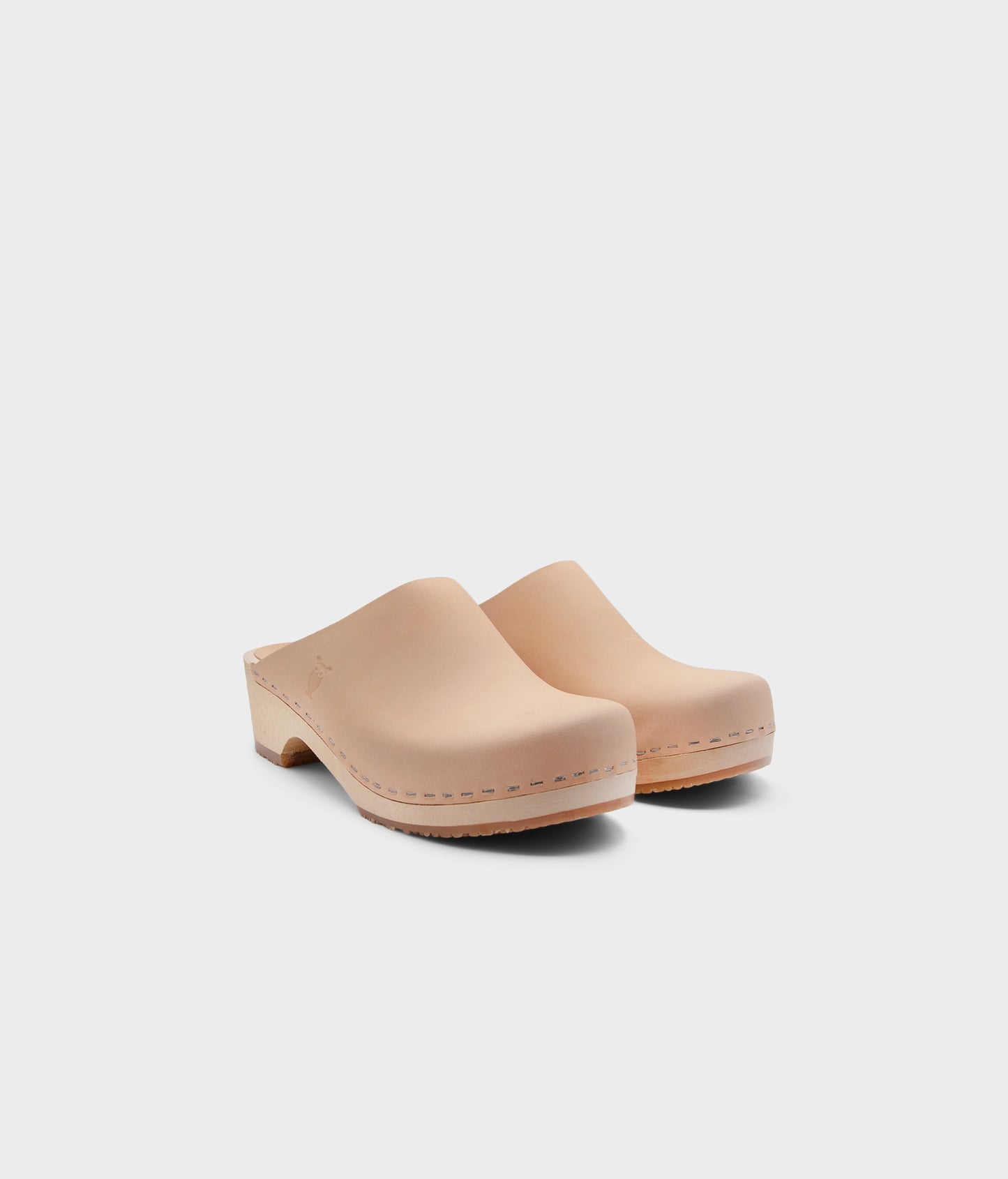 low heeled minimalistic clog mules in ecru beige vegetable tanned leather stapled on a light wooden base