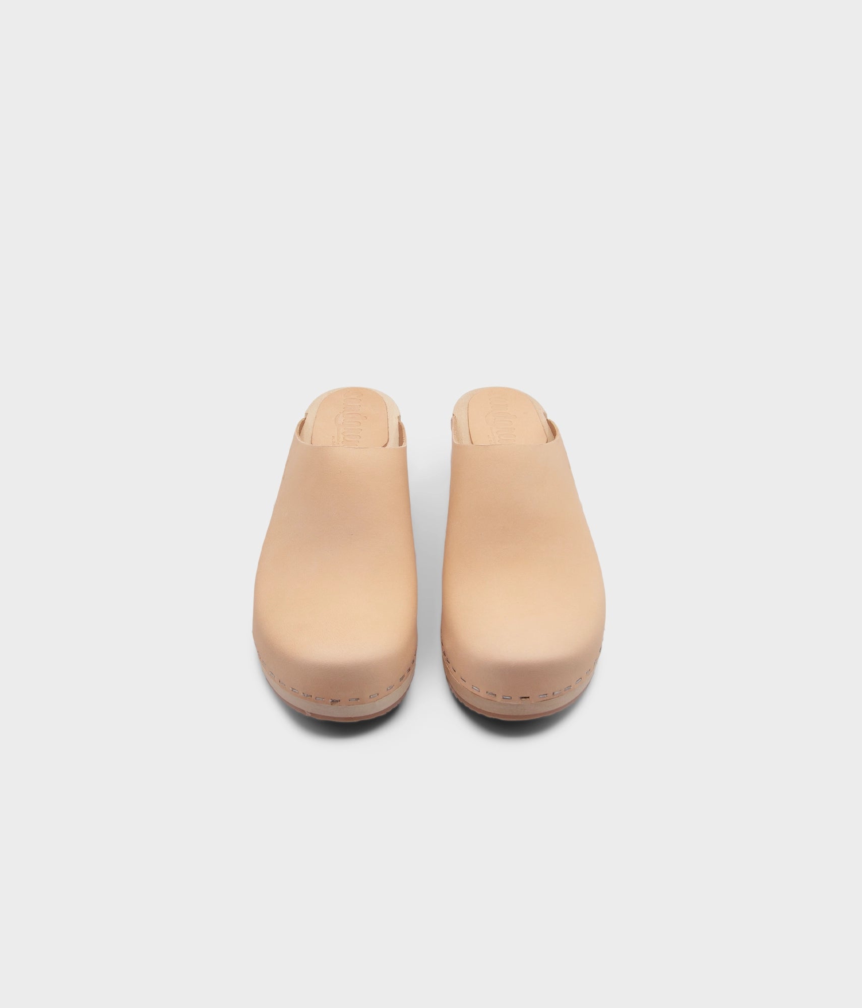 low heeled minimalistic clog mules in ecru beige vegetable tanned leather stapled on a light wooden base