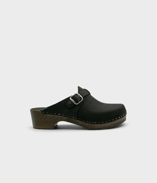 men's clog mule in black nubuck leather stapled on a dark wooden base with a silver buckle on top