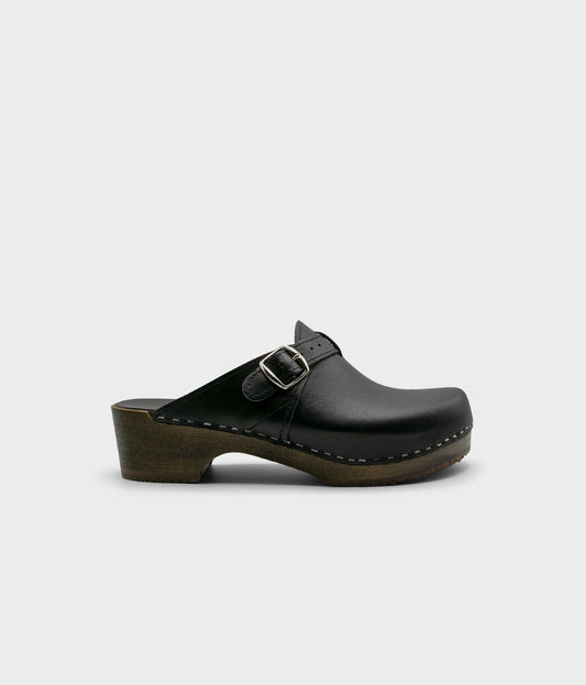 men's clog mule in black vegetable tanned leather stapled on a dark wooden base with a silver buckle on top