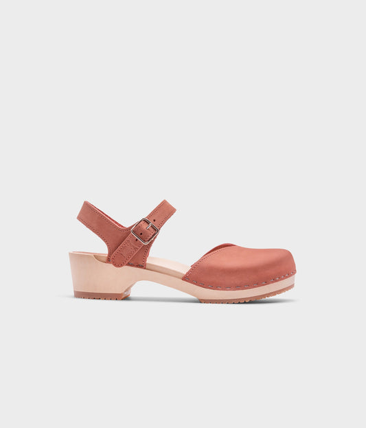 classic low heeled closed-toe sandal in blush pink nubuck leather stapled on a light wooden base