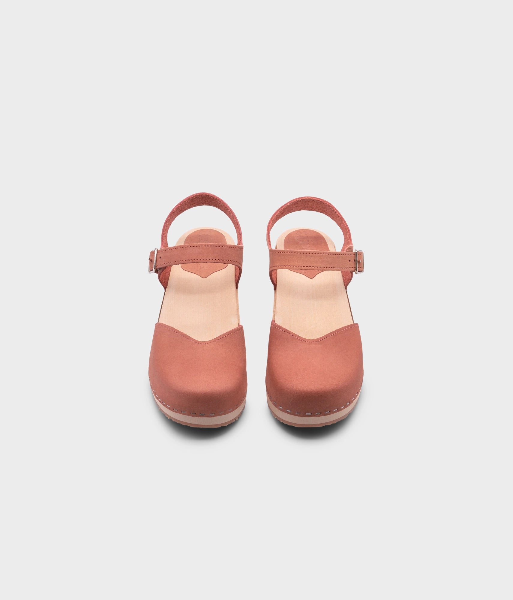 classic low heeled closed-toe sandal in blush pink nubuck leather stapled on a light wooden base