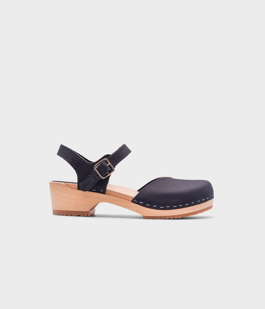 classic low heeled closed-toe sandal in navy blue nubuck leather stapled on a light wooden base