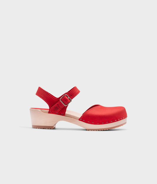 classic low heeled closed-toe sandal in red nubuck leather stapled on a light wooden base