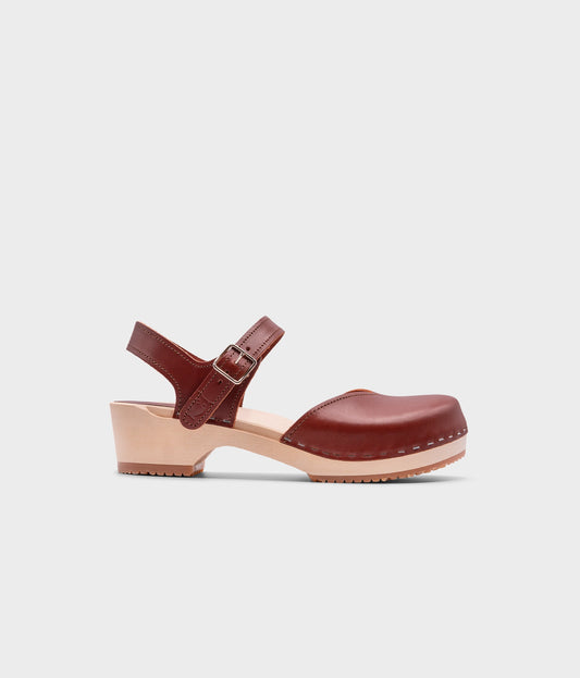 classic low heeled closed-toe sandal in cognac red vegetable tanned leather stapled on a light wooden base