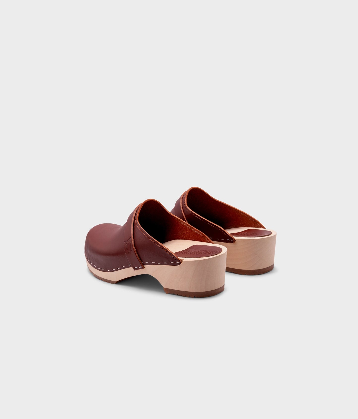 classic low heeled clog mule in cognac red vegetable tanned leather stapled on a light wooden base with a leather strap