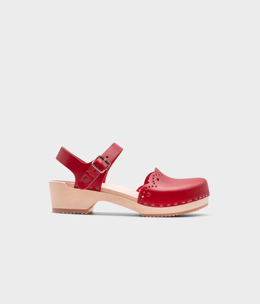 low heeled closed-toe clog sandals in red vegetable tanned leather with a wavy leather cutout stapled on a light wooden base