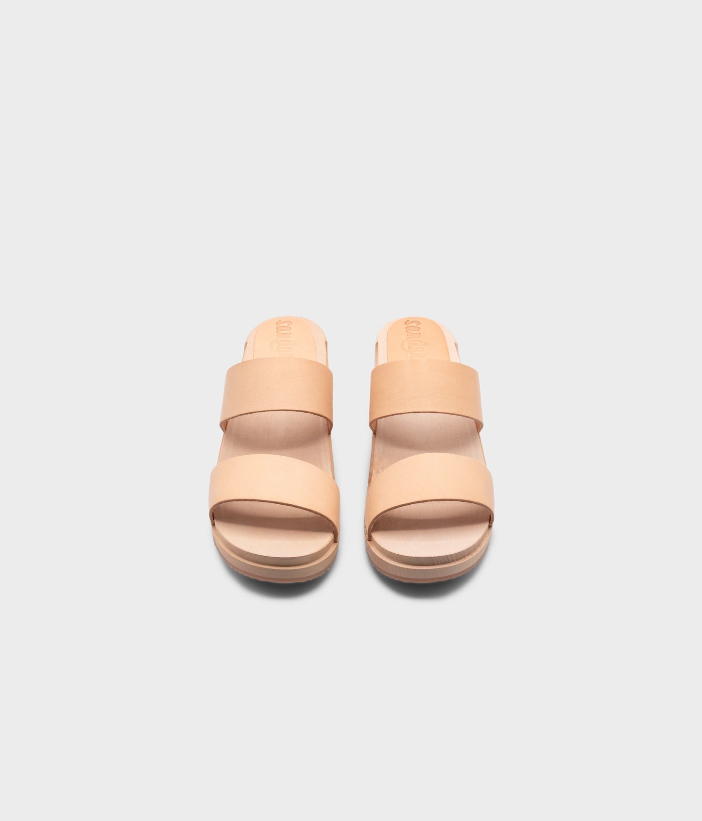 low heeled slip-in clog sandal with open toe in beige ecru vegetable tanned leather stapled on a light wooden base