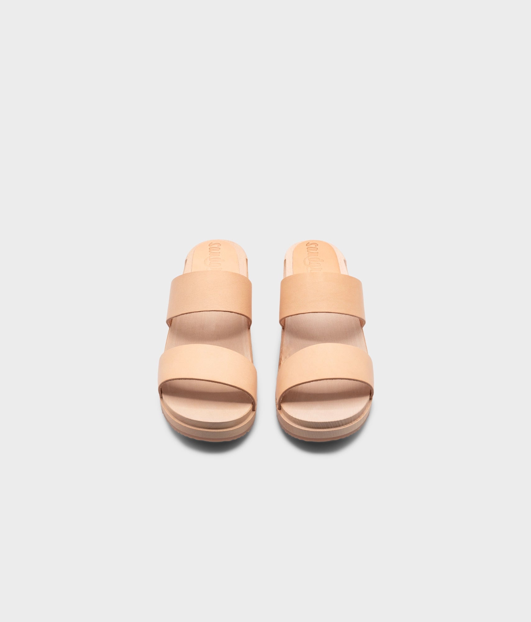 low heeled slip-in clog sandal with open toe in beige ecru vegetable tanned leather stapled on a light wooden base