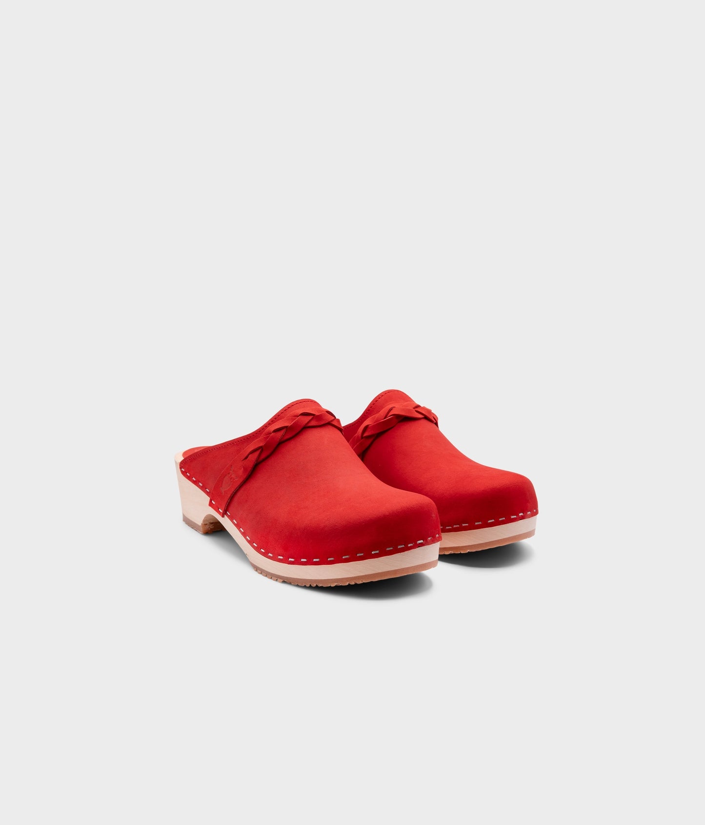 low heeled clog mules in red nubuck leather with a braided strap stapled on a light wooden base