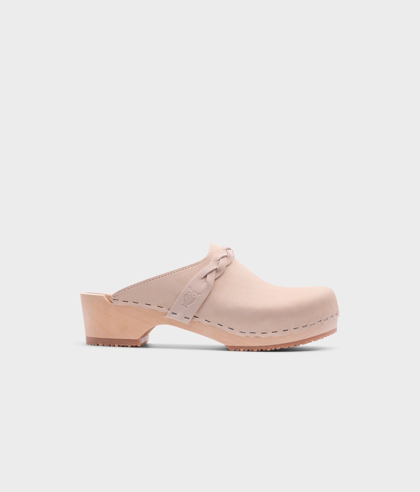 low heeled clog mules in sand white nubuck leather with a braided strap stapled on a light wooden base