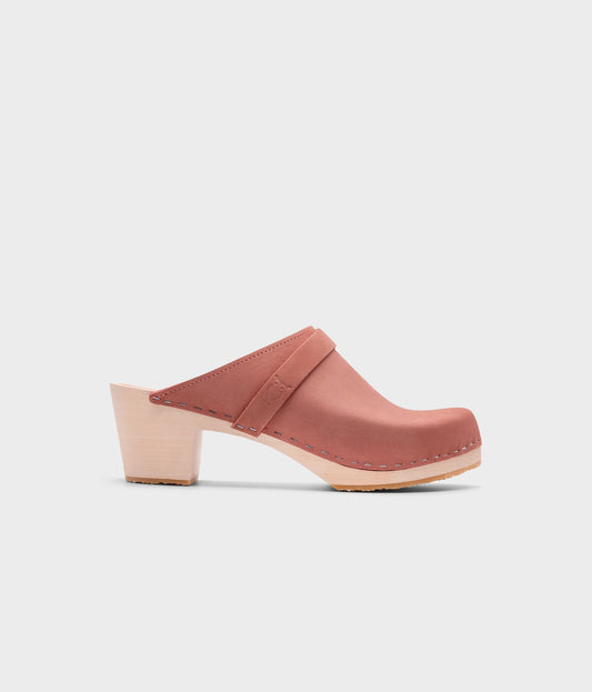 classic high heeled clog mule in blush pink nubuck leather stapled on a light wooden base with a leather strap