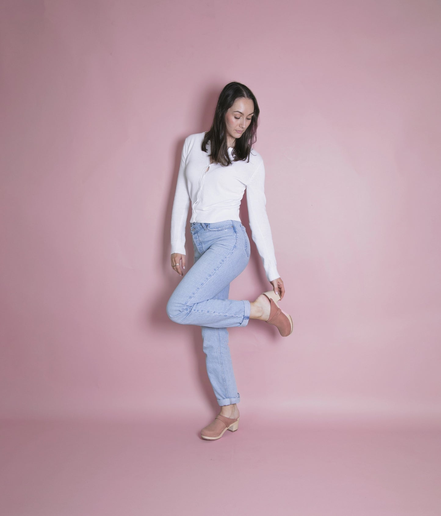 classic high heeled clog mule in blush pink nubuck leather stapled on a light wooden base with a leather strap