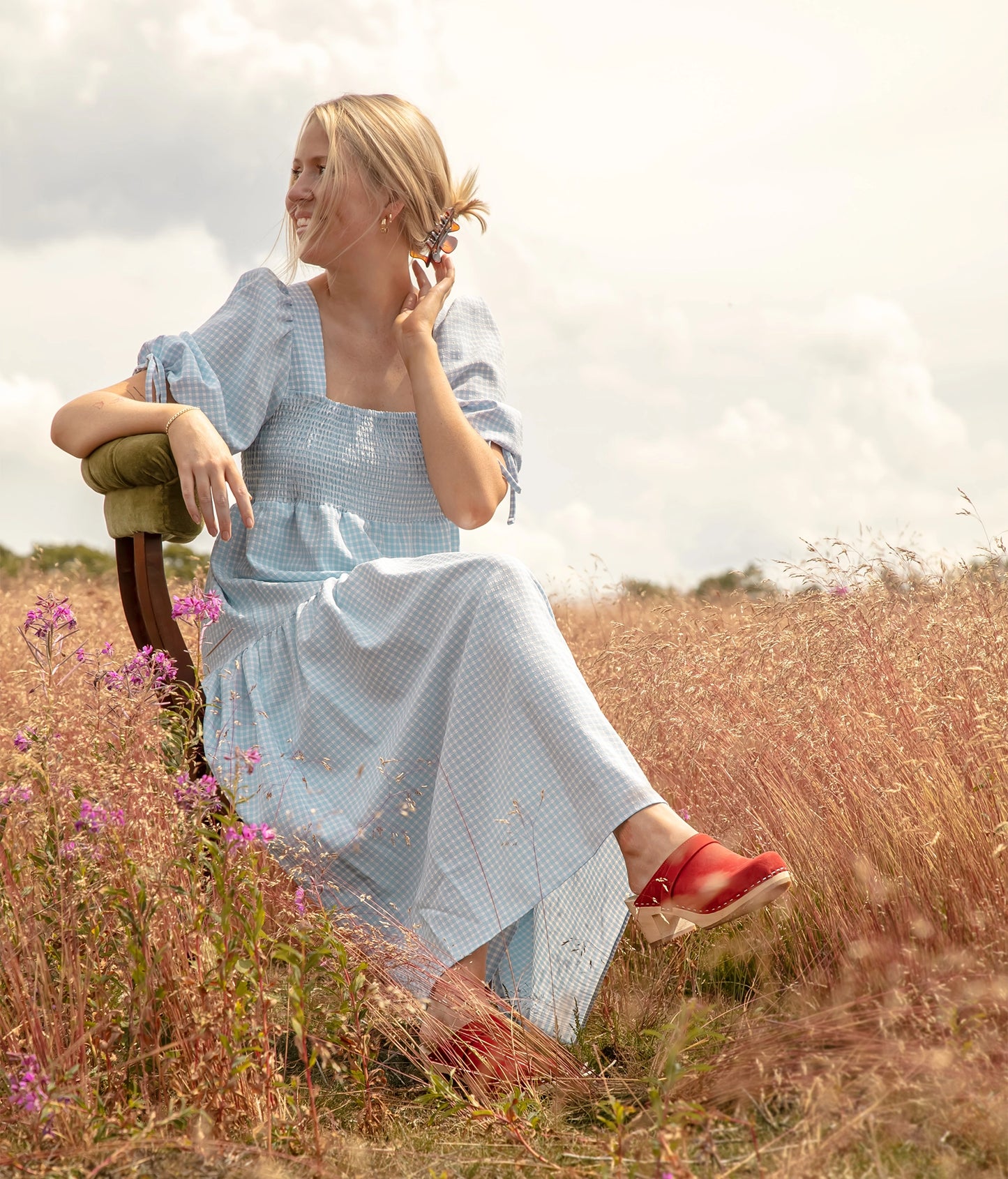 classic high heeled clog mule in red nubuck leather stapled on a light wooden base with a leather strap