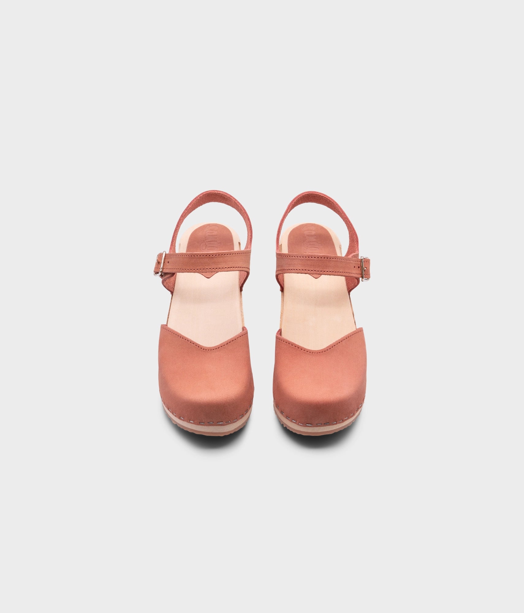 high heeled closed-toe clog sandal in blush pink nubuck leather stapled on a light wooden base
